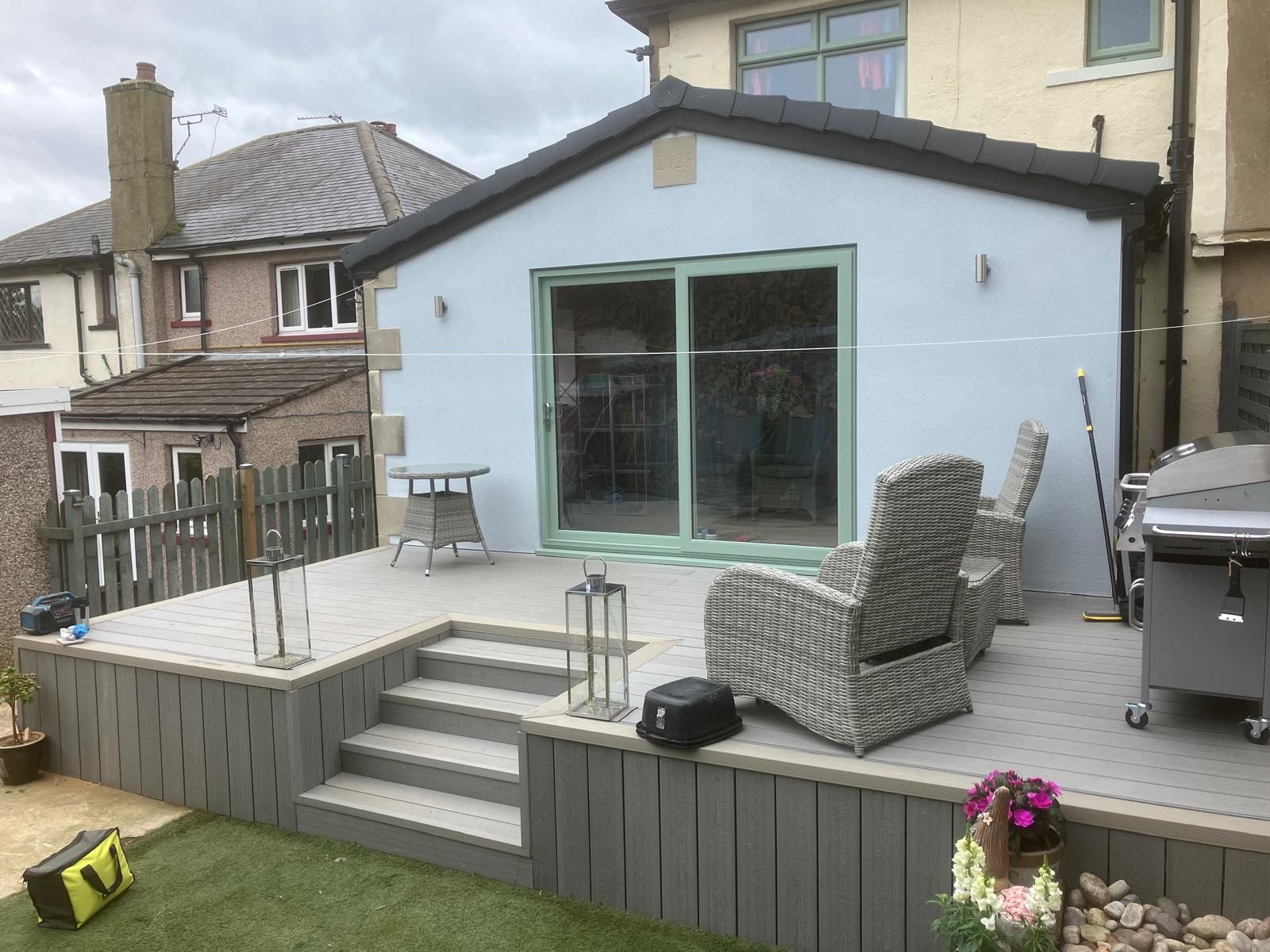 A finished rendered extension with sliding doors and decking