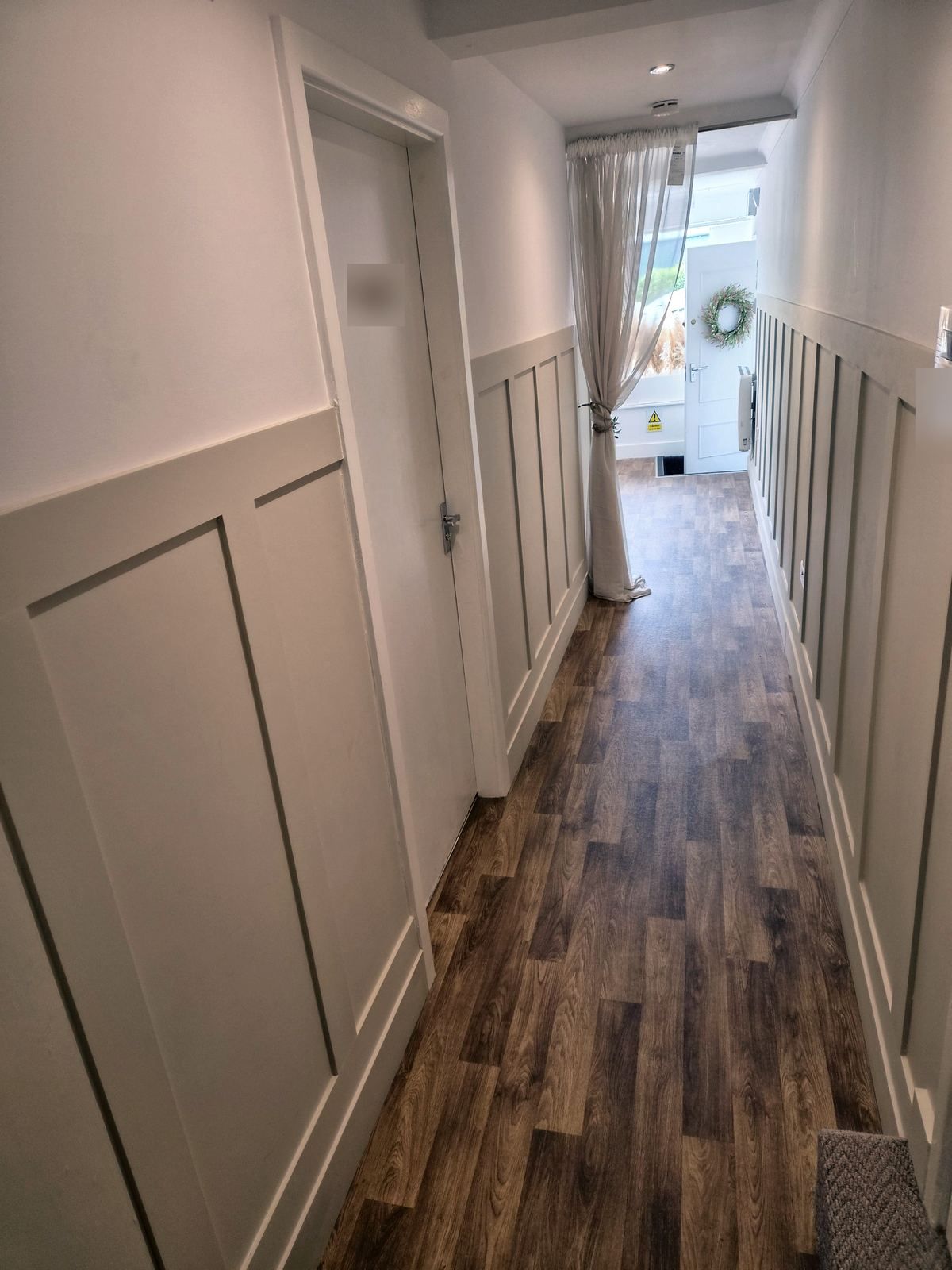 A panelled hallway with a wood floor